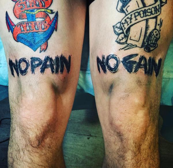 Tattoo that says no pain no gain handwritten on the