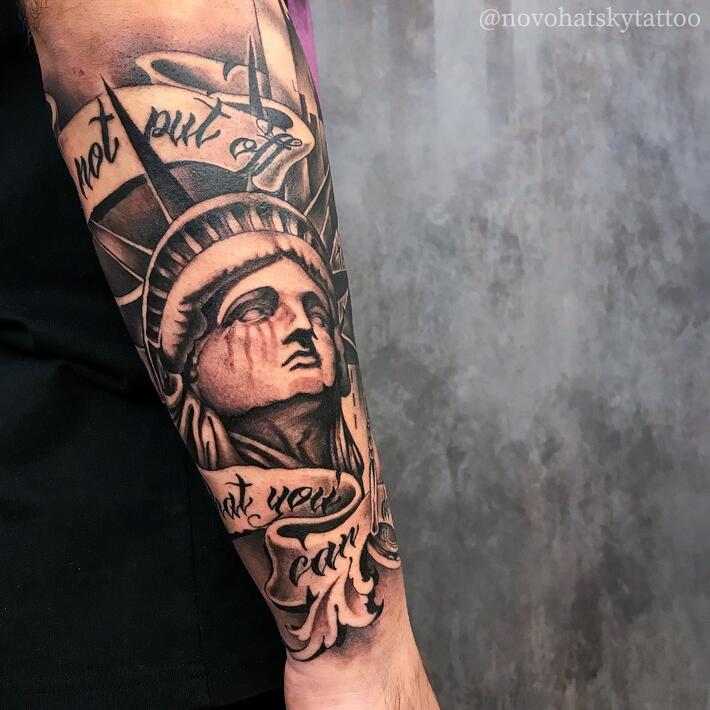 Statue of Liberty tattoo on the right inner forearm